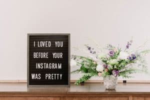 Instagram für Selbständige: Ist es die richtige Marketingplattform für dich? Hier zu sehen ist ein Letterboard mit dem Spruch "I loved you before your instagram was pretty" und ein Blumenstrauß.